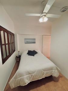 a bedroom with a white bed with a ceiling at Cozy House Malbec Route piscina parrilla bici 2 dormitorios in Maipú