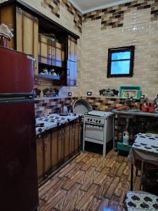 a kitchen with wooden cabinets and a stove top oven at Venti house in Aswan