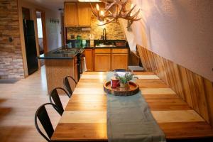 a kitchen with a long wooden table with chairs at Covered Hot Tub Getaway Sleeps 9 in Duck Creek Village +15 photos