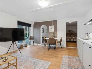 a kitchen and living room with a large flat screen tv at 5 star holiday home in Søby Ærø in Søby +12 photos