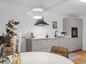 a kitchen with white cabinets and a table with a candle at 5 star holiday home in Søby Ærø in Søby
