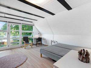 a bedroom with a bed and a desk and windows at 5 star holiday home in Hundested in Kulhuse