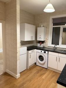 a kitchen with a washing machine and a washer at Modern 1-Bedroom Flat Near London City Airport in London
