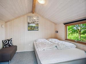a bed in a small room with a window at 5 star holiday home in Skælskør in Egerup