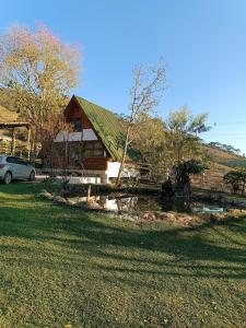 ein Haus mit einem davor geparkten Auto in der Unterkunft Casa da cachoeira na serra in Santo Antônio do Pinhal