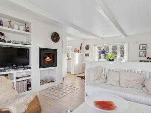 a living room with a couch and a fireplace at 5 star holiday home in Nykøbing M in Tæbring +13 photos