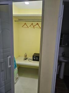 un placard avec une étagère avec une radio et des cintres dans l'établissement Eastern Breeze, à Hainamosa