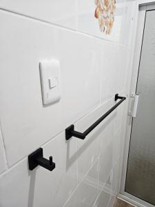 une salle de bains avec un mur blanc et un interrupteur dans l'établissement Eastern Breeze, à Hainamosa