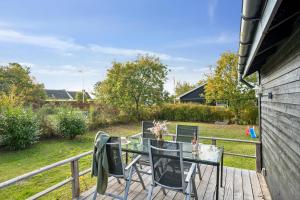エーベルトフトにあるAwesome Home In Ebeltoft With 2 Bedrooms And Internetのガラス張りのテーブルと椅子付きのデッキ