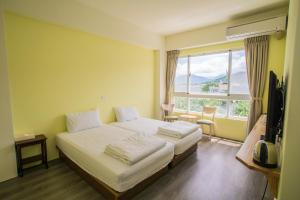 a hotel room with a bed and a large window at Siang Jhan B&B in Taitung City