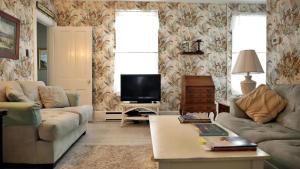 un soggiorno con un divano e una TV di The Windsor Cottage a Cape May