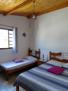 a bedroom with two beds and a window at Recanto da Estação in São Lourenço