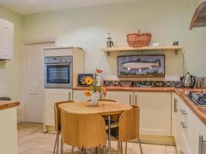 cocina con mesa de madera y mesa pequeña con sillas en Lakeland Villa, en Bowness-on-Windermere