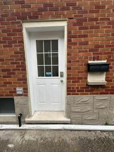 a white door on the side of a brick building at Modern 2 Bedroom Suite, Excellent Location Near Downtown & Airport in Kitchener