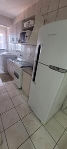 a white refrigerator in a kitchen with white appliances at Beira Mar,vista incrivel 6km Beto Carrero in Navegantes