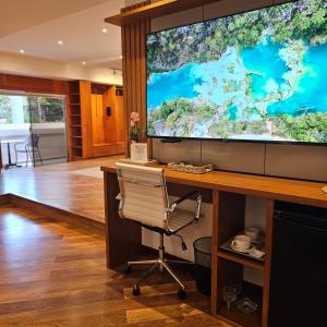 an office with a large screen tv and a desk at Green Palace Hotel Boutique in Asunción