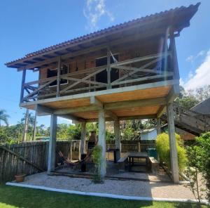 a large wooden building with a picnic table in a yard at Canto da Aracuã in Praia do Rosa