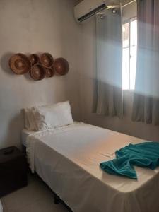 een bed in een kamer met een raam en een bedvisor bij Vila das Conchas - Estalagem in Japaratinga