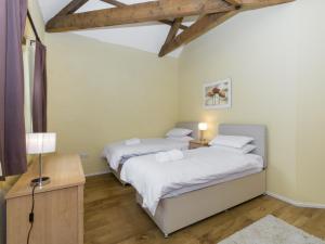 two beds in a room with wooden floors at Ingleby Barn - 27946 in Battersby