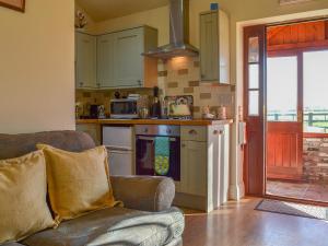 a living room with a couch and a kitchen at The Old Chapel in Burshill