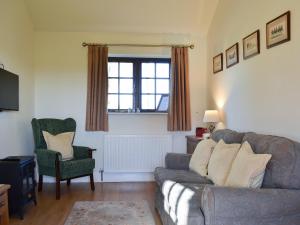a living room with a couch and a chair at The Old Chapel in Burshill