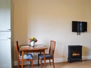 a dining room table with chairs and a stove at The Old Chapel in Burshill