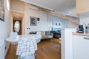 una cucina e un soggiorno con tavolo e sedie di The Best Rent - Beautiful apartment with balcony in Porta Romana a Milano