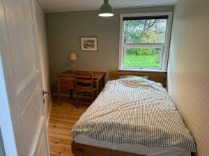 a bedroom with a bed and a window and a desk at 5 star holiday home in Rørvig in Rørvig