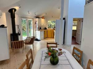 a kitchen with a table with a vase of flowers on it at 5 star holiday home in Rørvig in Rørvig