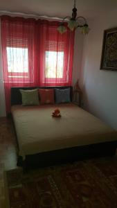 a bedroom with a large bed with a red window at Apartment Krstin Banja Vrujci in Gornja Toplica