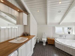 a bathroom with two sinks and a tub and a toilet at 5 star holiday home in Haderslev in Råde