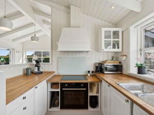 a kitchen with white cabinets and a counter top at 5 star holiday home in Haderslev in Råde +16 photos