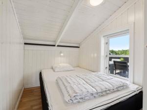 a white bedroom with a bed and a window at 5 star holiday home in Haderslev in Råde