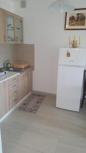 a kitchen with a white refrigerator and a sink at Apartment Krstin Banja Vrujci in Gornja Toplica