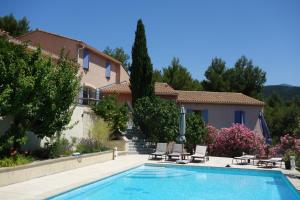 a swimming pool in front of a house at La Pinède du Barroux in Le Barroux