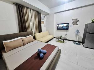 a living room with a large bed and a tv at A&G Condotel at 101 Newport Near NAIA T3 in Manila