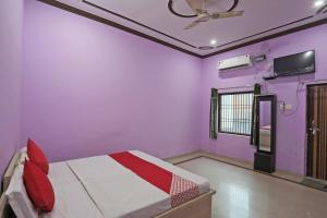 1 dormitorio con paredes moradas y 1 cama con techo en Hotel O Surprise Farm House, en Aligarh