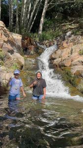 dos personas de pie en el agua frente a una cascada en Apart melgar familiar, en Girardot