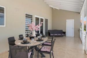 a dining room with a table with chairs and flowers at luxe villa met panormisch zicht en privézwembad in Fontein