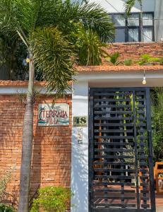a door to a building with a sign and a palm tree at Terralia Villa in La Gi