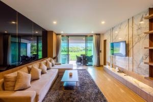a living room with a large couch and a table at TEVA Valley Resort in Chiang Rai