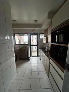 a kitchen with a large white tiled floor at Apartment 3 suites cop30 in Belém