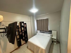 a small bedroom with a bed and a television at Apartment 3 suites cop30 in Belém
