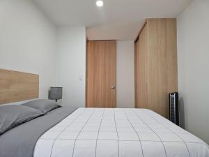 een slaapkamer met een groot wit bed en houten kasten bij NSI Alameda Park Humboldt Mexico City in Mexico-Stad