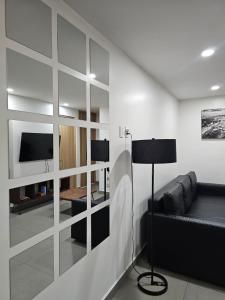 een woonkamer met een bank en een tv bij NSI Alameda Park Humboldt Mexico City in Mexico-Stad