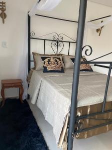 um quarto com uma cama com uma moldura de metal preto em Castelo Romântico em Pindamonhangaba mais 34 fotografias