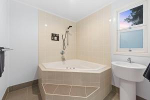 a bathroom with a tub and a sink and a window at Wallace Cottage - Glennie, CBD, Quiet Leafy Street in Toowoomba +10 photos