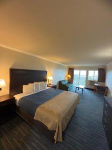 a hotel room with a large bed and a large window at Coratel Inn and Suites By Jasper Ocean Shores in Ocean Shores