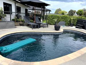 a swimming pool with a blue raft in the water at Pool, Spa pool, Private, Modern, Clive! in Clive