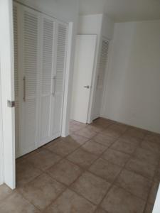 an empty room with white doors and a tile floor at Chalet Palm Condo in Rancho Mirage